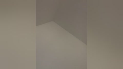 A video featuring a minimalist interior scene with a beige wall and corner, showing a simple, clean, and uncluttered space.