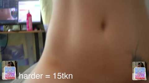 Video of a bare, slender, fair-skinned torso with a small navel, set against a blurred background featuring a television screen displaying a pink bottle and a green chair. Text reads \"h\u00e4rder = 15km\" (harder = 15km).