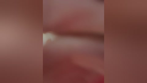 Video of a close-up, blurred view of a person's lips and nose, featuring soft, muted pink and brown tones, likely taken in a dimly lit room.
