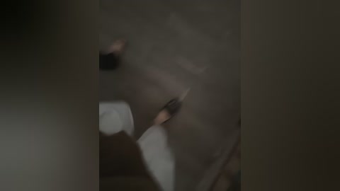 A dimly lit video of a blurred, close-up scene, possibly depicting a person or object obscured by shadows, creating an enigmatic and mysterious atmosphere.