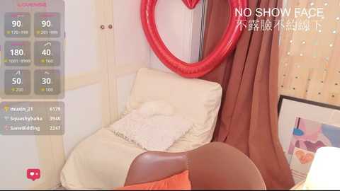 A video of a cozy, child-friendly room with a cushioned chair, red heart-shaped cushion, beige pillow, and brown curtains. The background features a wall-mounted clock, a digital screen displaying a \"NO SHOW FACE\" message, and a soft, pastel-colored artwork.