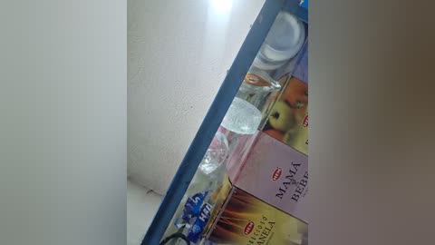 Media: Video of a messy refrigerator interior, with various food items and containers, including yogurt, cheese, and eggs, visible through a narrow gap between the door and the side.