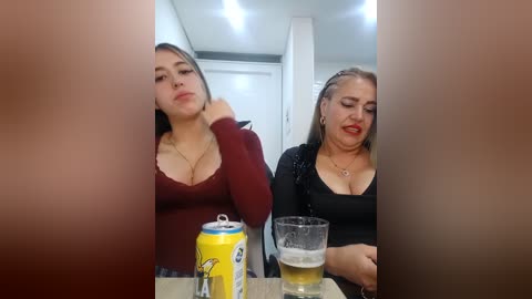 Video of two women in a modern kitchen; one with long dark hair in a red top, the other with blonde hair in a black top.