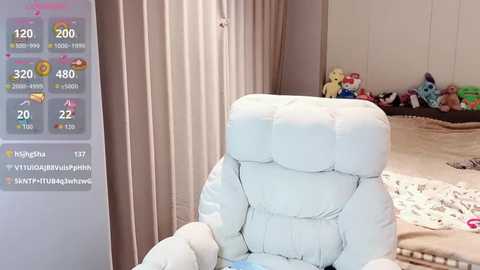 A video of a plush, light blue chair in a child's bedroom with a digital display showing \"Higashi\" with 177 followers and 1,470 hearts. The room has white walls, a teddy bear, and toys.