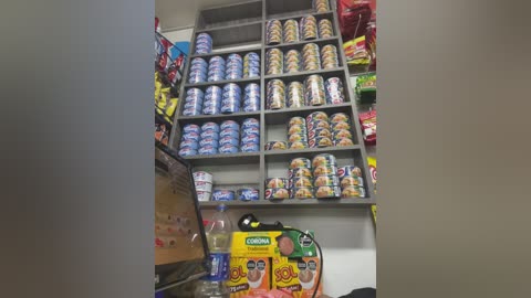 Video of a well-organized candy store display, featuring multiple shelves filled with colorful, wrapped candies and snacks. The background shows a variety of packages, including chips and drinks, creating a vibrant, eye-catching scene.