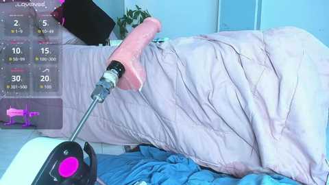 Video of a messy bedroom with a pink vibrator on a blue quilted blanket, a digital timer displaying 15 minutes, and a closed door in the background.