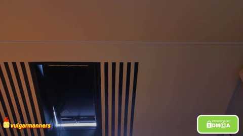 Video of a beige ceiling with a rectangular vent featuring vertical black and white stripes. The vent has a dimly lit interior, suggesting an air conditioning unit. \"Vigamans\" logo is present.