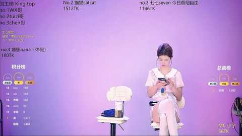 Video of an Asian woman with dark hair in a white dress and white knee-high socks, sitting on a white stool, focused on her phone. Background displays a purple gradient with Chinese text and a digital interface.