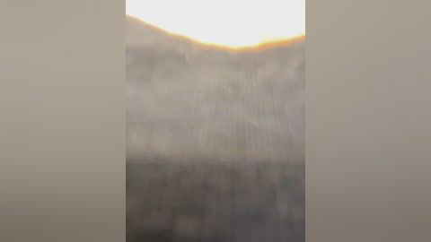 A video of a dense, foggy landscape with a hazy, indistinct horizon. The image is slightly blurred, creating an ethereal, dreamlike atmosphere. The colors are muted, with shades of grey and white dominating.