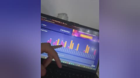 Video of a person's hand interacting with a laptop screen displaying a colorful bar chart with purple, pink, and yellow bars. The background is blurred with a purple gradient.