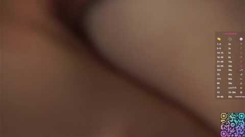 A blurry, grainy video of a person's torso with a large, undefined object, possibly a smartphone, on the right side.