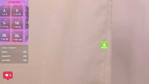 A video depicting a close-up of a white sheet with a small green sticker, overlaid with a grid showing game stats, including scores, points, and a red heart icon.