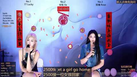 Video of two women, one with blonde hair and the other with black hair, holding microphones, singing on stage in front of a colorful, abstract background.