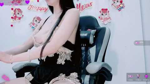 A video of an Asian woman in a black lace lingerie set, seated in a black gaming chair, with cat-themed decor and \"Happy Meow\" text in the background.