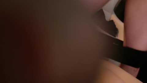 Video of a person with a light skin tone, wearing a black top, with blurred background suggesting intimacy or a private moment.