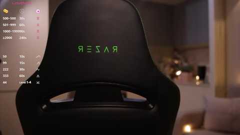 Media: A video of a black gaming chair with the word \"\u0420\u0415\u0421\u041f\u0410\u0412\u0420\" (Russian for \"REPAIR\") in green letters, displayed in a dimly lit room with a soft, beige sofa and a cozy atmosphere.