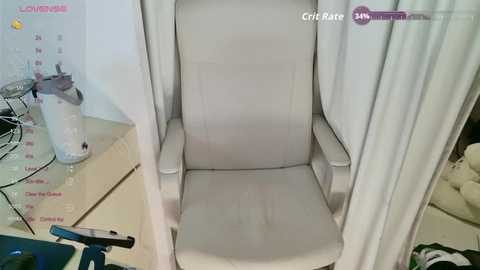 A video shows a beige office chair with a high backrest in a well-lit room. The chair is positioned in front of a white wall calendar with a \"Low Battery\" label. A desk with a glass jar and a black object is visible in the background.