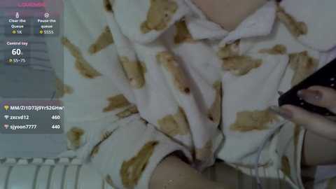 Media: A video of a person in a white, patterned pajama top, holding a smartphone, with a virtual chat interface overlay showing chat messages and a thermometer.