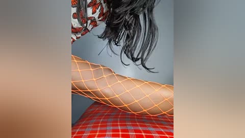 Video of a person with long, black hair, wearing orange fishnet stockings and a red plaid skirt, standing against a gray wall adorned with a butterfly-patterned tapestry.