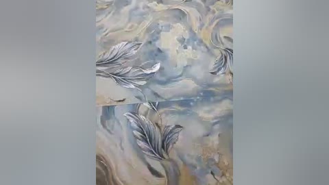 A video of an abstract painting featuring metallic silver feathers against a textured, blended background of soft blues and grays, creating a serene, ethereal atmosphere. The feathers appear to be floating in the air, enhancing the sense of movement and light.