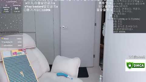 Video of a modern, minimalist living room with white furniture, including a couch and chair, a closed door, and a digital clock displaying \"AM 01:10:45.\